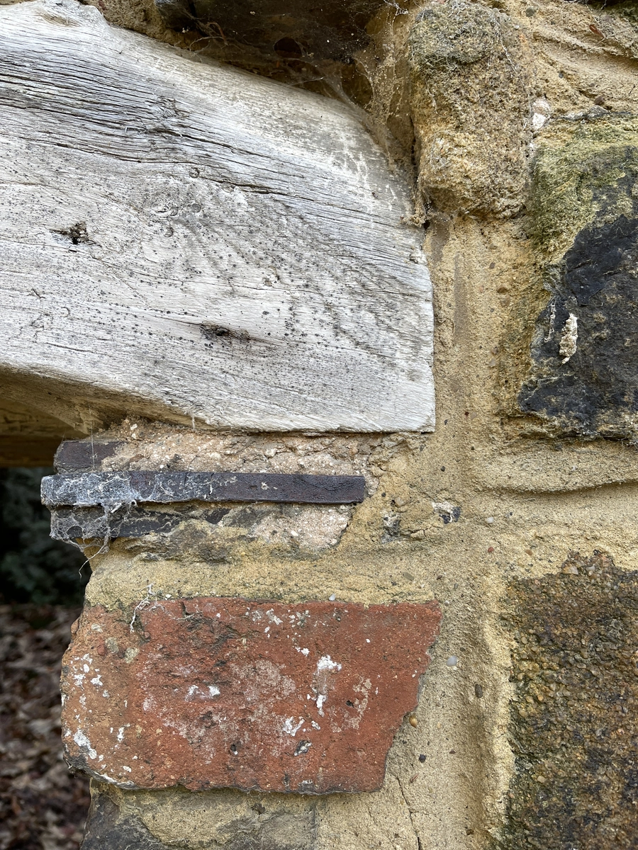 End of a timber lintel with an iron fixing, over brick